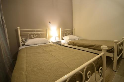 two beds in a small room with a lamp at Moutros Cozy Home in Sokrakion