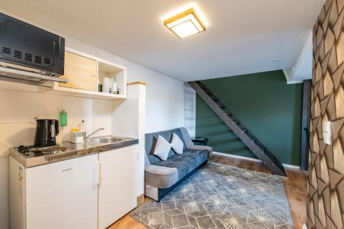 a living room with a couch and a kitchen at Pension Michelangelo in Eisenach