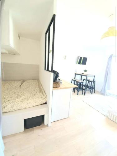 une petite chambre avec un lit et une table dans l'établissement Appartement à 500m de la plage, à Canet