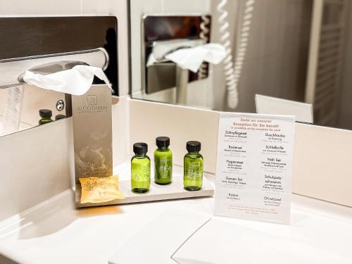 two bottles of olive oil sitting on a counter with a menu at Golfhotel & Restaurant Lindenhof in Bad Vilbel