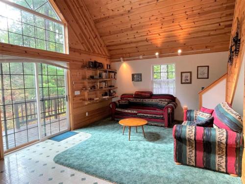 a living room with a couch and a table at Mossy Moose Cabin | Near White Pass & Mt Rainier in Packwood