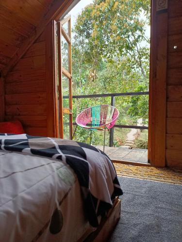a bedroom with a bed and a table on a balcony at Cabaña en el Campo in La Vega