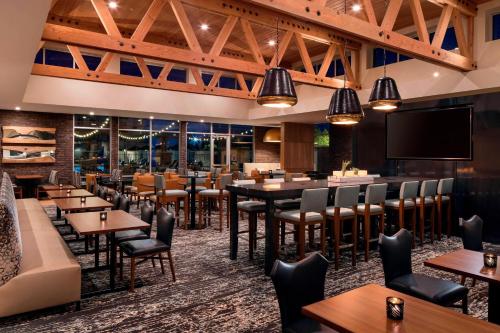 a restaurant with tables and chairs and a flat screen tv at Residence Inn by Marriott Redwood City San Carlos in San Carlos