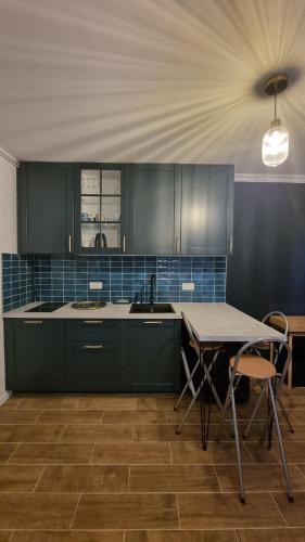 une cuisine avec des placards verts et une table avec des chaises dans l'établissement Studio bleu pleyel, à Saint-Denis