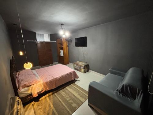 a bedroom with a bed and a couch at Recanto da Cachoeira RJ in Magé