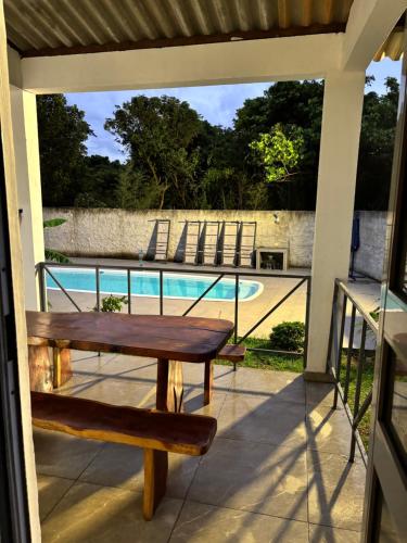 a porch with a bench and a swimming pool at Recanto da Cachoeira RJ in Magé