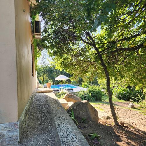 a walkway next to a house with a tree at Apart exclusivo piscina BIA Encanto serrano Stay&Flow in Río Ceballos