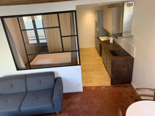 a living room with a couch and a large mirror at Le Nid Urbain in Villefranche-sur-Saône