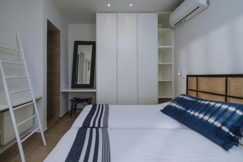 a bedroom with a white bed and shelves at Villa Morby in Paleros