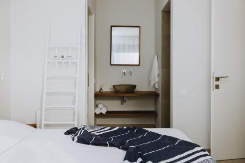 a bedroom with a bed and a bathroom with a sink at Villa Morby in Paleros