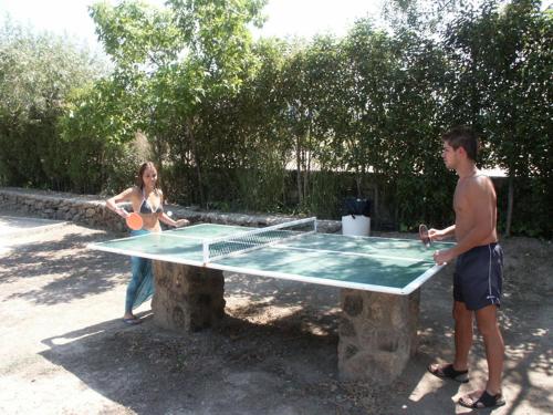 a man and a woman playing a game of table tennis at Complejo Turístico Las Cañadas Casas de Campo- Actividades Gratuitas Todos los Fines de Semana in Baños de Montemayor