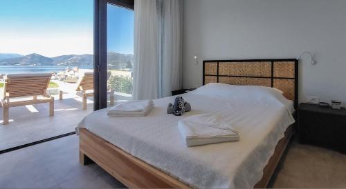 a bedroom with a large bed with a view of the ocean at Villa Pale Rosa in Paleros