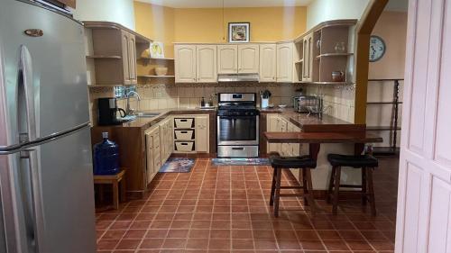 a kitchen with a refrigerator and a table in it at El Remanso de paz y tranquilidad in San Pablo Nuevo Abajo