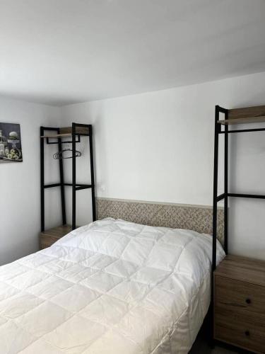 - une chambre avec un lit blanc et 2 étagères dans l'établissement Résidence 114-pleneuf Val Andre - Studio refait à neuf proche de la mer MAE-8071, à Pléneuf-Val-André