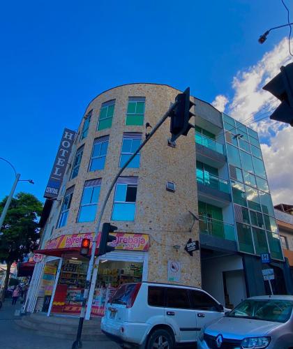 a building with a car parked in front of it at Hotel Buenos Aires Central in Medellín