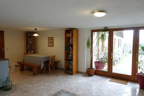 - un salon avec une table, une fenêtre et une table dans l'établissement Appartement rez-de-chaussée dans vielle ferme au coeur des Vosges, à Plainfaing