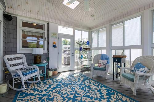 a screened in porch with chairs and a rug at A Shore Thing in Chester