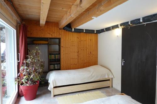 une chambre avec un lit et une étagère dans l'établissement Appartement rez-de-chaussée dans vielle ferme au coeur des Vosges, à Plainfaing
