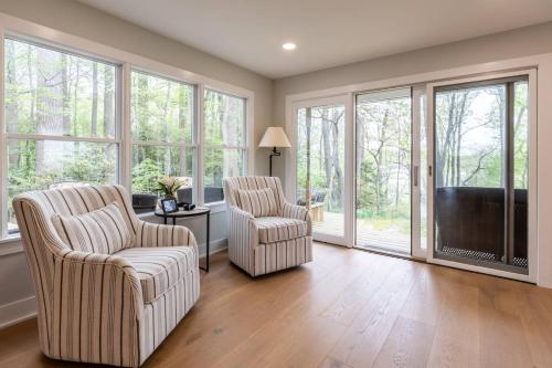 two chairs and a television in a living room with windows at Riverfront Hangar in Crownsville