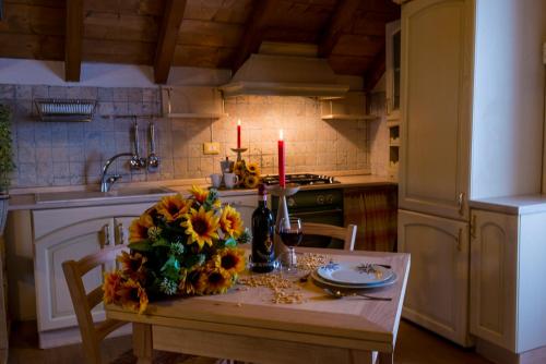 a kitchen with a table with flowers and candles on it at Il Borgo Dei Celti in Fiumalbo
