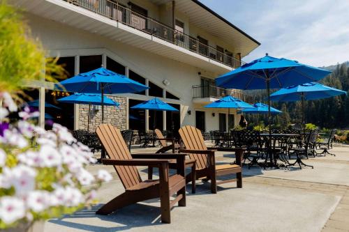 a group of chairs and blue umbrellas on a patio at Best Western Lodge at River's Edge in Orofino