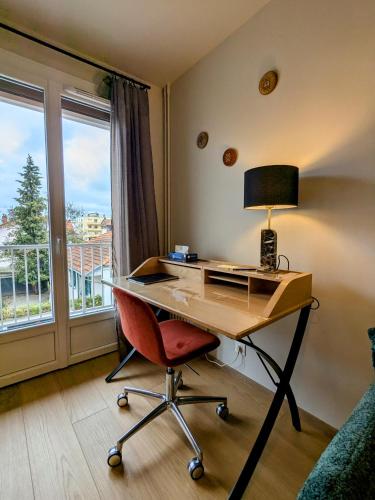 Cette chambre dispose d'un bureau avec une lampe et une chaise. dans l'établissement Le sublime, à Le Coteau