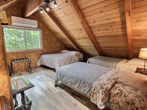 Un dormitorio con dos camas en una cabaña de madera. en Papa`s Packwood Cabin, en Packwood