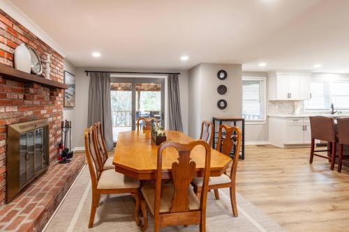a dining room with a wooden table and a fireplace at Liberty Call in Arnold