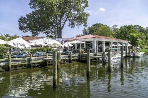 a dock with tables and umbrellas on a body of water at Liberty Call in Arnold