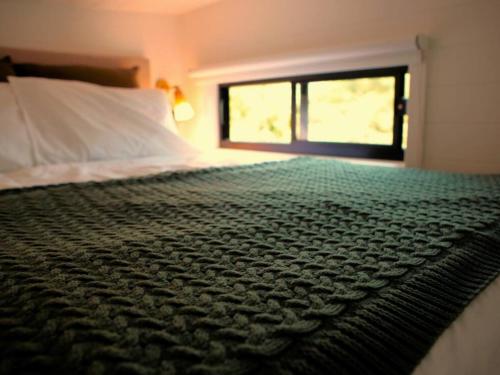 a bedroom with a large bed with a window at Kookaburra's Perch in Millgrove