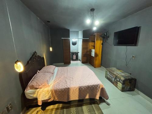 a bedroom with a bed and a flat screen tv at Recanto da Cachoeira RJ in Magé