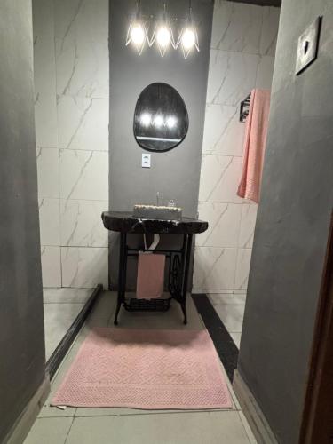 a bathroom with a sink and a mirror on the wall at Recanto da Cachoeira RJ in Magé