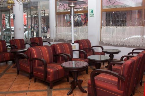 a waiting room with red chairs and tables at Hotel Hacienda Puno Centro Histórico in Puno