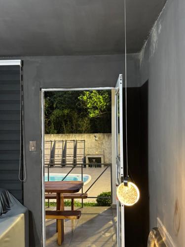 an open door to a patio with a table and a pool at Recanto da Cachoeira RJ in Magé