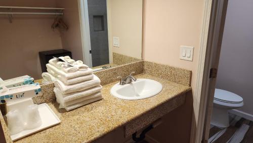a bathroom with a sink and a toilet and a mirror at Royal Century Hotel at LAX in Inglewood