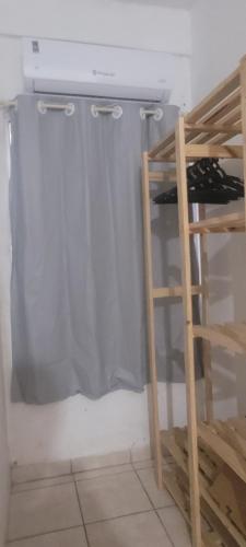 a room with a shower curtain and a shelf at Excelente kitnet mobiliada pertinho mar in Vila Velha