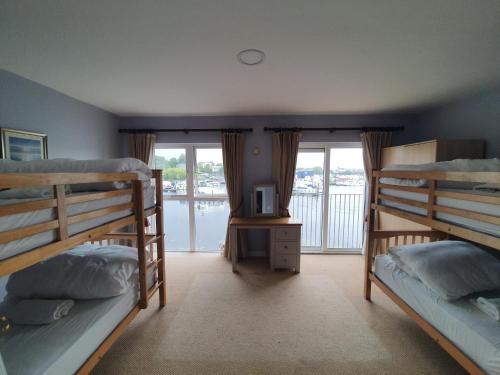 a bedroom with three bunk beds and a balcony at Scenic River Shannon Three bedroom house in Carrick on Shannon