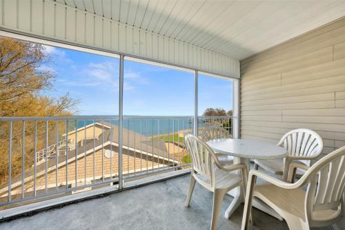 a balcony with a table and chairs and a view of the ocean at Bayshore Resort At Put-In-Bay in Put-in-Bay