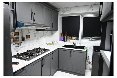 a kitchen with a stove and a sink and a window at Ajman Pearl Tawer Block B4-807 in Ajman 