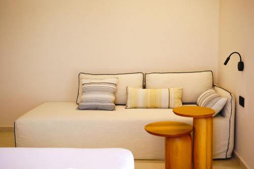 a bed with two pillows and a table in a room at Agave Donousa Suites in Donoussa