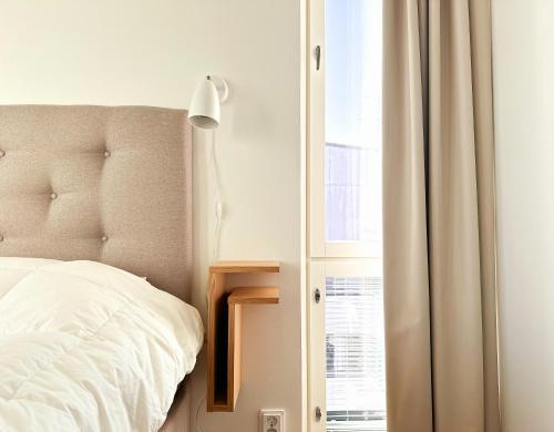 ein Schlafzimmer mit einem weißen Bett und einem Fenster in der Unterkunft City Center Suite with sauna in Rovaniemi