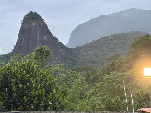 a view of a mountain with trees and a street light at Recanto da Cachoeira RJ in Magé