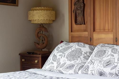 a bed with a pillow and a lamp on a night stand at Ravenwood in Packwood