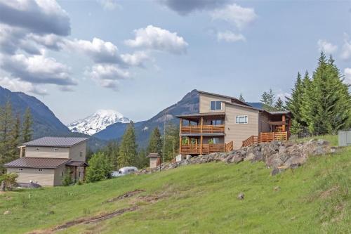 a house on a hill with mountains in the background at Ravenwood in Packwood