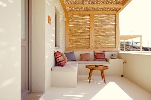 a small balcony with a bench and a table at Agave Donousa Suites in Donoussa