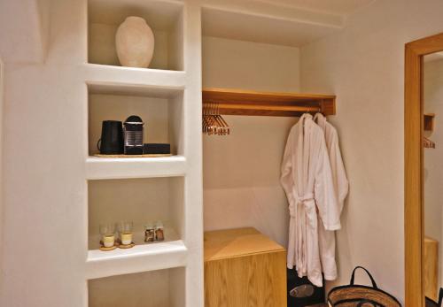 a small bathroom with a closet with a shelf at Agave Donousa Suites in Donoussa