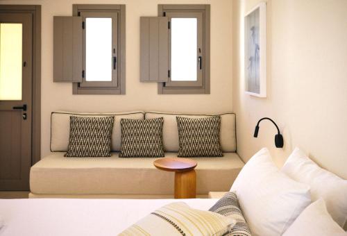 a living room with a couch and two windows at Agave Donousa Suites in Donoussa