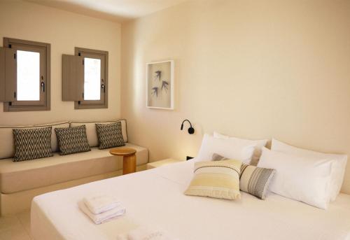 a white bedroom with a bed and a couch at Agave Donousa Suites in Donoussa