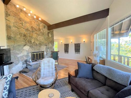 a living room with a couch and a stone fireplace at Valley View Cabin in Packwood