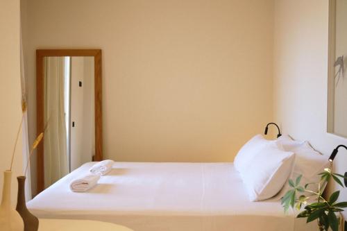 a bedroom with a white bed with a mirror at Agave Donousa Suites in Donoussa